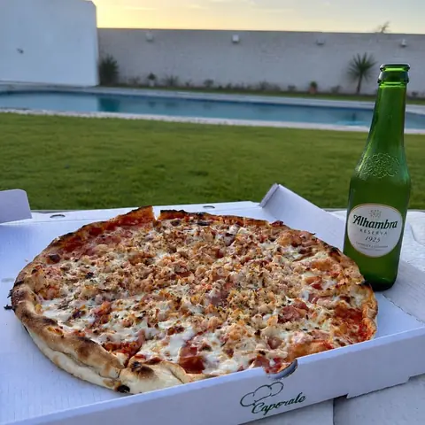Pizza de Caporale en caja junto a una piscina