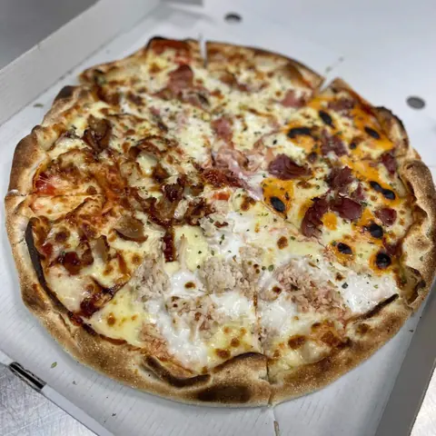 Pizza de cuatro sabores en su caja de Caporale